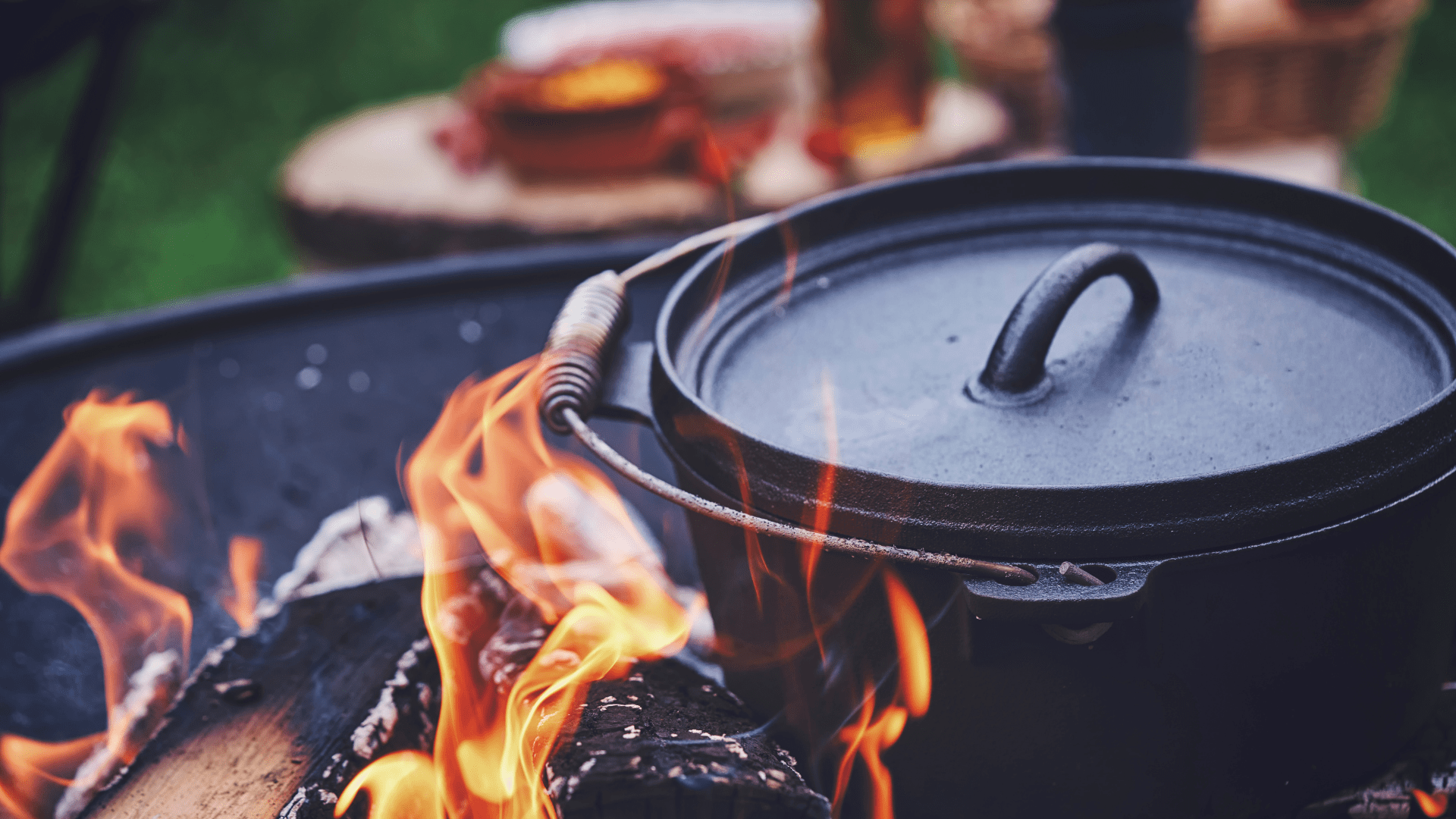 Dutch oven amid the flames of a campfire.